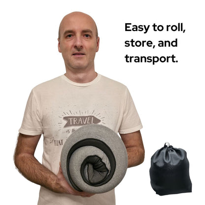Beyond Travel Pillow | Ergonomic, Adjustable, Portable travel pillow shown rolled for compact storage, held by a man, with included black carry bag.