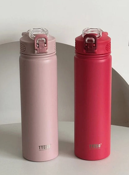 Two pink and red water bottles with clear lids on a white surface.